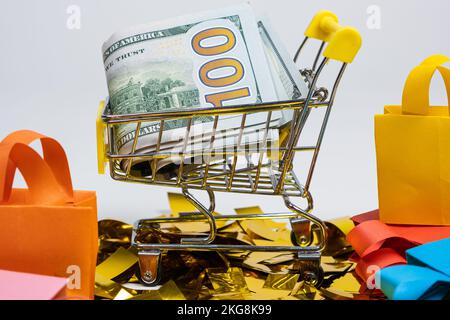 Einkaufstaschen und ein Wagen mit Geld auf weißem Hintergrund. Das Konzept des Verkaufs. Stockfoto