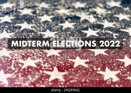 Schreiben Sie die Zwischenwahlen 2022 auf einen schäbigen Abdruck von Sternen der amerikanischen Flagge mit horizontalem rotem Lichtleck. Konzept der politischen Teilung Stockfoto