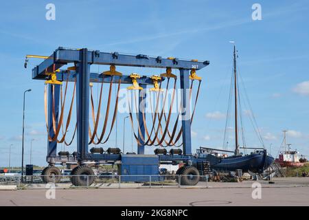 Großer leerer mobiler Bootslift in einem Hafen unter blauem Himmel. Yachtservice in einem Yachthafen. Hebt große Boote für Wartung und Neulackierung Stockfoto