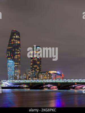 Entlang der Aufnahme, die vom Nordufer der Themse aufgenommen wurde und die Blackfriars Station auf der Brücke über den Fluss mit Turmblock zeigt Stockfoto