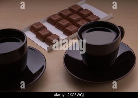 Fotografieren Sie zwei Kaffeetassen Kaffee und Scheiben Schokolade Stockfoto