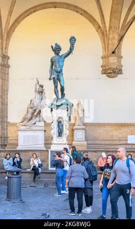 Statue von Perseus mit dem abgetrennten Kopf der Medusa, von Cellini,1554 - mit den Touristen Loggia del Lanzi, Piazza della Signoria, Florenz, Italien Stockfoto