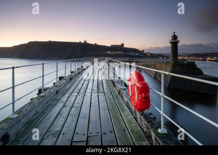 Ein Wintersonnenaufgang über Whitby Piers Stockfoto