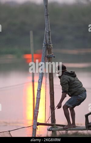 Fischer, die Netze in der untergehenden Sonne aussetzen, Dibru-Saikhowa, Assam, Indien Februar Stockfoto