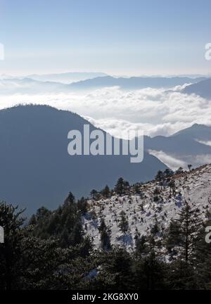 Genießen Sie den Blick auf verschneite Hänge am Morgen mit Wolken im Valley Eaglenest Wildlife Sanctuary, Arunachal Pradesh, Indien Januar Stockfoto