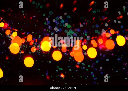 Abstrakter Hintergrund mit bunten Bokeh-Lichtern, Blots und Farbspritzern. Verschwommene städtische festliche Beleuchtung, Beleuchtung Stockfoto