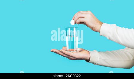 Glas Wassertablette. Glas mit ferveszierender Tablette in Wasser mit Blasen. Weiße Pille und ein Glas Wasser in Menschenhänden. Gesundheitskonzept. Nahaufnahme von Stockfoto