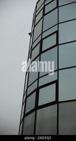 Fliesen aus Spiegeln. Verspiegelte Fenster quadratisch. Rundes Gebäude. Außenverglasung. Stockfoto