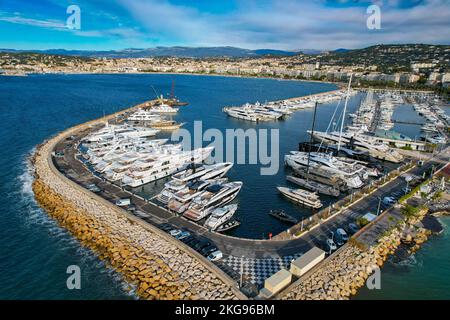 Luftaufnahme über dem Yachthafen von Cannes an der französischen Riviera. Ich schaue auf Mega Yacht's mit La croisette im Hintergrund. Stockfoto