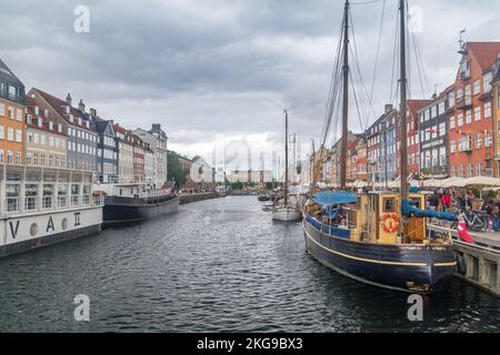 Kopenhagen, Dänemark - 26. Juli 2022: Blick auf das berühmte Nyhavn am bewölkten Tag, Ufer, Kanal und Unterhaltungsviertel aus dem 17.. Jahrhundert in Kopenhagen. Stockfoto