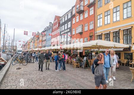 Kopenhagen, Dänemark - 26. Juli 2022: Nyhavn Uferpromenade aus dem 17.. Jahrhundert, voller Touristen. Stockfoto