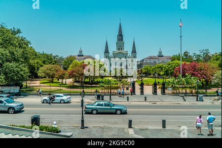 Ein Blick auf die Straße von Jackson Square in New Orleans, mit St.. Louis Cathedral im Hintergrund, mit Verkehr und Menschen auf der Straße Stockfoto