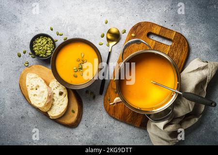 Kürbissuppe im Topf am Steintisch. Stockfoto