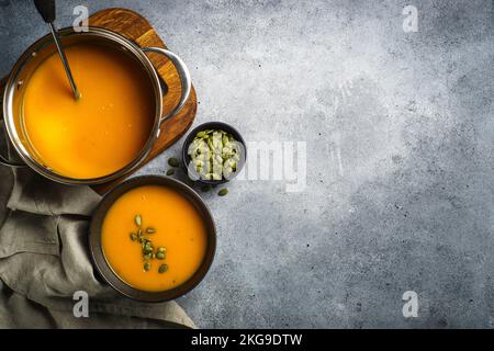 Kürbissuppe im Topf am Steintisch. Stockfoto