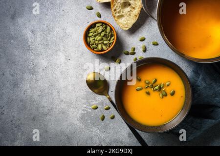 Kürbissuppe im Topf am Steintisch. Stockfoto