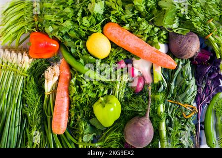Auswahl an frischem, farbenfrohem Bio-Gemüse auf weißem Tablett auf Holztannentisch, Essenshintergrund, Draufsicht Stockfoto