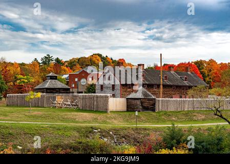 Ein schönes Gebäude hinter einem Holzzaun am Flussufer, umgeben von Herbstbäumen in Augusta, USA Stockfoto