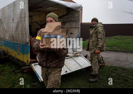 Nach dem Umzug des Teams in eine neue Basis wird ein ukrainischer Soldat gesehen, der eine Kiste vom Lastwagen trägt. Ukrainische Truppen befreiten die südliche regionale Hauptstadt Cherson für etwa eine Woche, nachdem Russland sich zurück zum linken Ufer des Dnipro-Flusses zurückgezogen hatte. Die Stadt, die unter 8 Monaten besetzt war, hat noch immer keinen Strom, kein Wasser, schlechtes Signal und keine Versorgung mit Nahrungsmitteln. Stockfoto