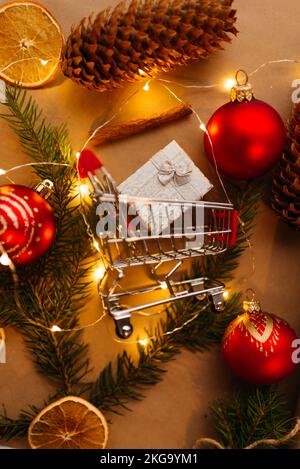 Einkaufswagen in Weihnachtslichtern. Weihnachtsdekorationen kaufen Stockfoto