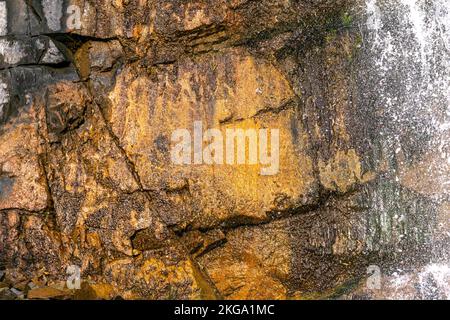 Gelbe, braune Felsformation mit natürlichem Wasser frpm darüber Stockfoto