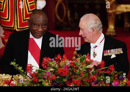 Der südafrikanische Präsident Cyril Ramaphosa und König Charles III sitzen zusammen beim Staatsbankett, das im Buckingham Palace, London, während des Staatsbesuchs des südafrikanischen Präsidenten im Vereinigten Königreich abgehalten wird. Bilddatum: Dienstag, 22. November 2022. Stockfoto