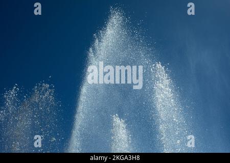 Wasserstrahlen gegen den Himmel. Brunnen in der Stadt. Details des Brunnens auf der Straße. Spritztropfen. Stockfoto