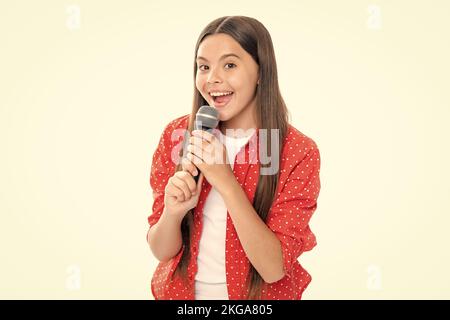 Hübsches kleines Mädchen, das mit dem Mikrofon singt. Porträt der emotionalen erstaunt aufgeregt Teenager-Mädchen. Porträt von glücklich lächelnd Teenager-Kind Mädchen. Stockfoto