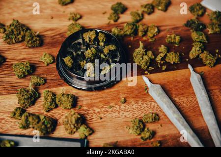 Schleifer Nahschuss, Gras und Kegel, Drogen im Gelenk auf einem Holztisch. Stockfoto