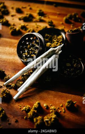 Schleifer und Fugen mit Marihuana-Pfeife. Drogen und Marihuana, Marihuana-Knospen. Sativa und indica сbd und tgk auf Holz. Gras und Räucherpflanzen. Stockfoto