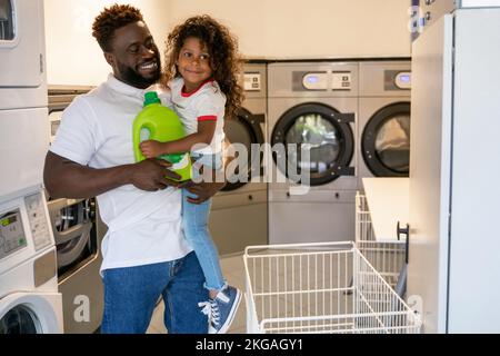 Liebevoller Vater und sein Kind in einem öffentlichen Waschsalon Stockfoto