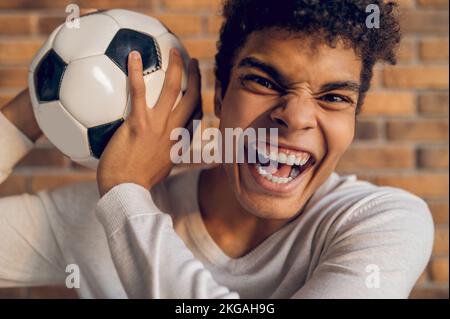 Aggressiver Fußballspieler, der in Innenräumen für die Kamera posiert Stockfoto