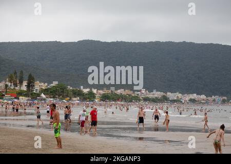 Bombinhas, Brasilien. 28. Dezember 2013. Die Leute genießen den Strand am Praia de Bombas während des bewölkten Tages in Bombinhas, Bundesstaat Santa Catarina, Brasilien. Stockfoto