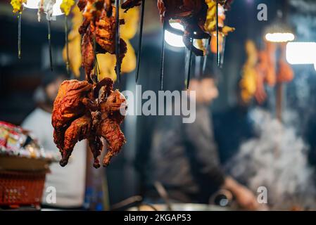 Srinagar, Indien. 22.. November 2022. Gegrilltes Hähnchen wird vor einem Café in Srinagar ausgestellt. Kaschmir ist berühmt für seine nichtvegetarische Küche und die meisten dieser Zubereitungen werden auch als Verkaufsware verkauft. Zu den gängigen nicht-vegetarischen Straßennahrungsmitteln von Kaschmir gehören Rista, Kabab, gebratener Fisch, Grillgerichte und Harisa; letztere sind die gängigsten und weithin akzeptierten Straßennahrungsmittel von Kaschmir. Kredit: SOPA Images Limited/Alamy Live News Stockfoto