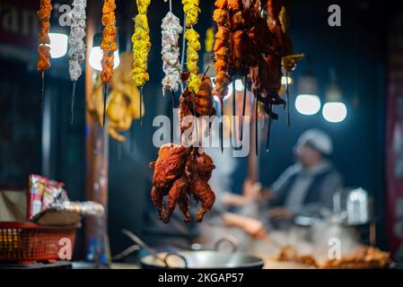 Srinagar, Indien. 22.. November 2022. Gegrilltes Hähnchen und Fleisch werden vor einem Café in Srinagar ausgestellt. Kaschmir ist berühmt für seine nichtvegetarische Küche und die meisten dieser Zubereitungen werden auch als Verkaufsware verkauft. Zu den gängigen nicht-vegetarischen Straßennahrungsmitteln von Kaschmir gehören Rista, Kabab, gebratener Fisch, Grillgerichte und Harisa; letztere sind die gängigsten und weithin akzeptierten Straßennahrungsmittel von Kaschmir. Kredit: SOPA Images Limited/Alamy Live News Stockfoto