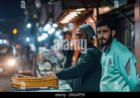 Srinagar, Indien. 22.. November 2022. Ein Verkäufer bereitet ein Barbecue in seinem Café in Srinagar zu. Kaschmir ist berühmt für seine nichtvegetarische Küche und die meisten dieser Zubereitungen werden auch als Verkaufsware verkauft. Zu den gängigen nicht-vegetarischen Straßennahrungsmitteln von Kaschmir gehören Rista, Kabab, gebratener Fisch, Grillgerichte und Harisa; letztere sind die gängigsten und weithin akzeptierten Straßennahrungsmittel von Kaschmir. Kredit: SOPA Images Limited/Alamy Live News Stockfoto