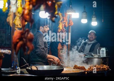 Srinagar, Indien. 22.. November 2022. Ein Verkäufer bereitet Essen vor seinem Café in Srinagar zu. Kaschmir ist berühmt für seine nichtvegetarische Küche und die meisten dieser Zubereitungen werden auch als Verkaufsware verkauft. Zu den gängigen nicht-vegetarischen Straßennahrungsmitteln von Kaschmir gehören Rista, Kabab, gebratener Fisch, Grillgerichte und Harisa; letztere sind die gängigsten und weithin akzeptierten Straßennahrungsmittel von Kaschmir. Kredit: SOPA Images Limited/Alamy Live News Stockfoto