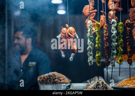 Srinagar, Indien. 22.. November 2022. Gegrilltes Hähnchen und Fleisch werden vor einem Café in Srinagar ausgestellt. Kaschmir ist berühmt für seine nichtvegetarische Küche und die meisten dieser Zubereitungen werden auch als Verkaufsware verkauft. Zu den gängigen nicht-vegetarischen Straßennahrungsmitteln von Kaschmir gehören Rista, Kabab, gebratener Fisch, Grillgerichte und Harisa; letztere sind die gängigsten und weithin akzeptierten Straßennahrungsmittel von Kaschmir. Kredit: SOPA Images Limited/Alamy Live News Stockfoto