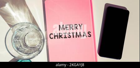 Textbeschriftung mit Frohe Weihnachten. Wort für eine jährliche Tradition zur Feier der Geburt Jesu Christi Stockfoto