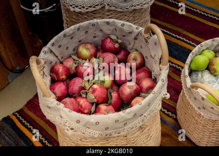 Rote und grüne Äpfel im Stroh Körbe in der Anzeige Stockfoto