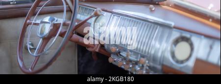 Verschwommenes Lenkrad, Schalthebel und Armaturenbrett eines restaurierten, alten Autos oder Autos. Stockfoto
