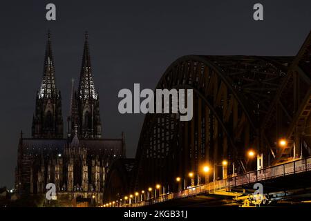 Energie sparen, Kölner Dom mit Hohenzollernbrücke nur spärlich beleuchtet bei Nacht, Köln, Rheinland, Nordrhein-Westfalen, Deutschland, Europa Stockfoto