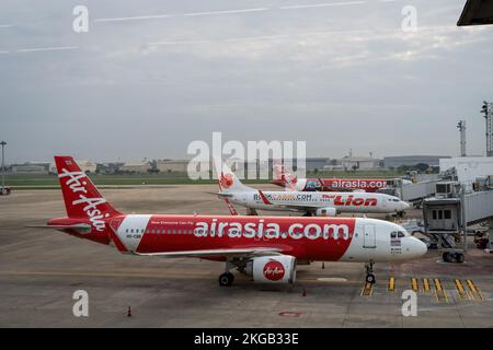 Bangkok, Thailand. 23.. November 2022. Die gewerblichen Passagierflugzeuge Thai Air Asia (FD) und Thai Lion Airbus A320-200 werden am internationalen Abflugterminal am Don Mueang International Airport (DMK) in Bangkok geparkt gesehen. Die internationale Reise in Thailand nimmt wieder zu, da ausländische Touristen schnell auf das Niveau vor der Pandemie ankommen, was erheblich zur Erholung der tourismusabhängigen Wirtschaft beiträgt. Kredit: SOPA Images Limited/Alamy Live News Stockfoto