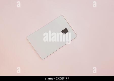 Fotomodell einer weißen Kreditkarte mit isoliertem Chip auf pinkfarbenem Hintergrund Stockfoto