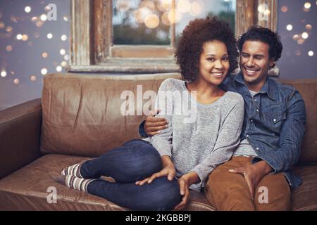 Ich genieße das Eheleben. Ein glückliches Paar, das zu Hause auf dem Sofa sitzt. Stockfoto
