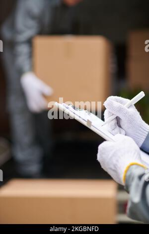 Nahaufnahme von Mover in Textil-glover-Fülldokument mit Kundendaten Stockfoto