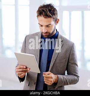 Schwerpunkt auf der aktuellen Technologie. Mann in einem modernen Anzug mit einem Tablet. Stockfoto