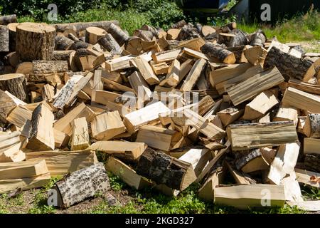 Ein Stapel gehacktes Holz im Hof des Hauses. Vorbereitung für den Winter Stockfoto