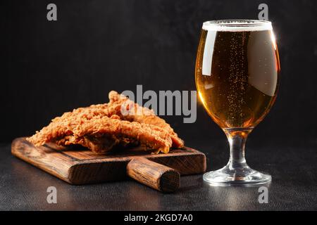 Eine Flasche Bier und verschiedene Snacks auf einem rustikalen Holztisch. Draufsicht. Hochwertiges Foto Stockfoto