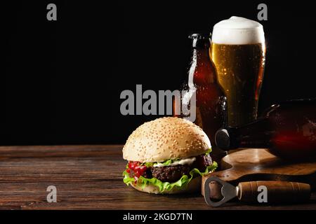 Set Hamburger Bier und pommes frites. Ein Standard-Set an Getränken und Speisen im Pub, Bier und Snacks. Dunkler Hintergrund, fast Food. Traditionelles amerika Stockfoto