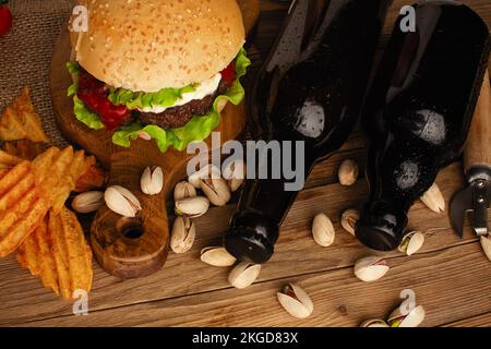 Set Hamburger Bier und pommes frites. Ein Standard-Set an Getränken und Speisen im Pub, Bier und Snacks. Dunkler Hintergrund, fast Food. Traditionelles amerika Stockfoto